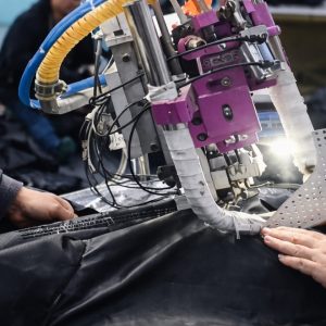 Factory worker assembling inflatable air beam structure for custom inflatable tent production