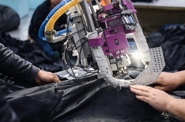 Factory worker assembling inflatable air beam structure for custom inflatable tent production