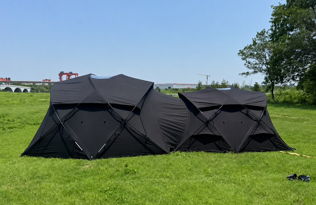 Connected black glamping tents outdoor side view