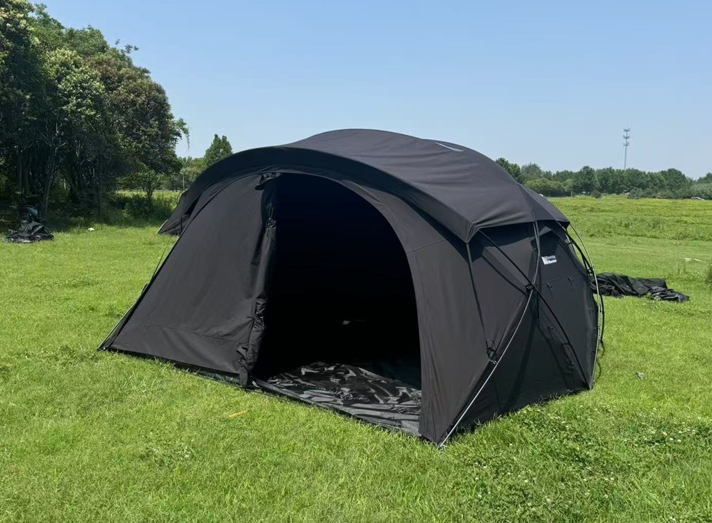 Outdoor setup of black glamping tent with front door open