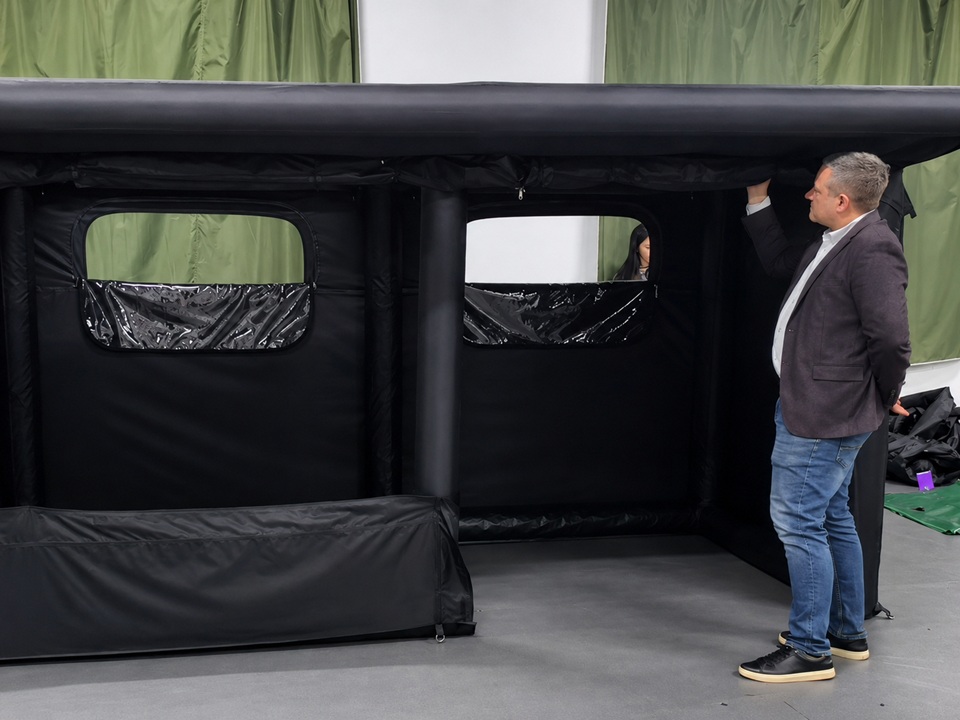 Customer reviewing an OEM inflatable shelter prototype during sample evaluation and product inspection