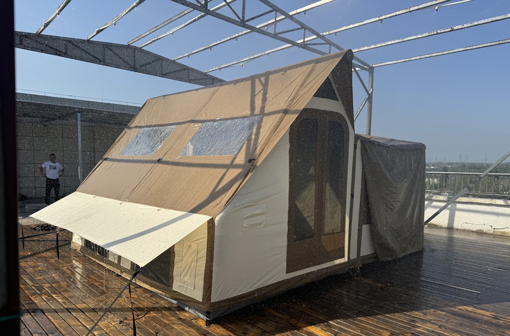 Cotton canvas glamping tent undergoing rain testing to evaluate waterproof performance before OEM production