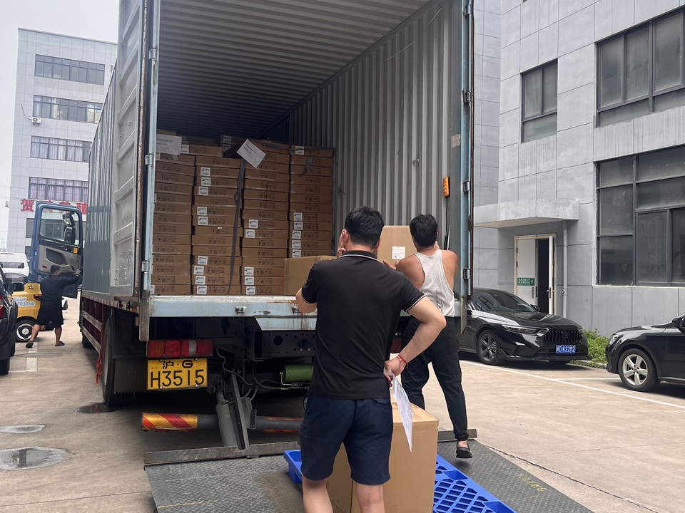 NastoCamp staff loading packaged tent products into an export shipping container before international delivery.