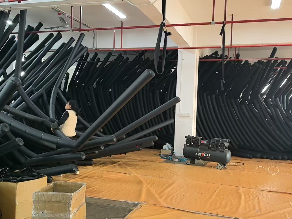 Workers preparing inflatable tent structures before mass production at NastoCamp