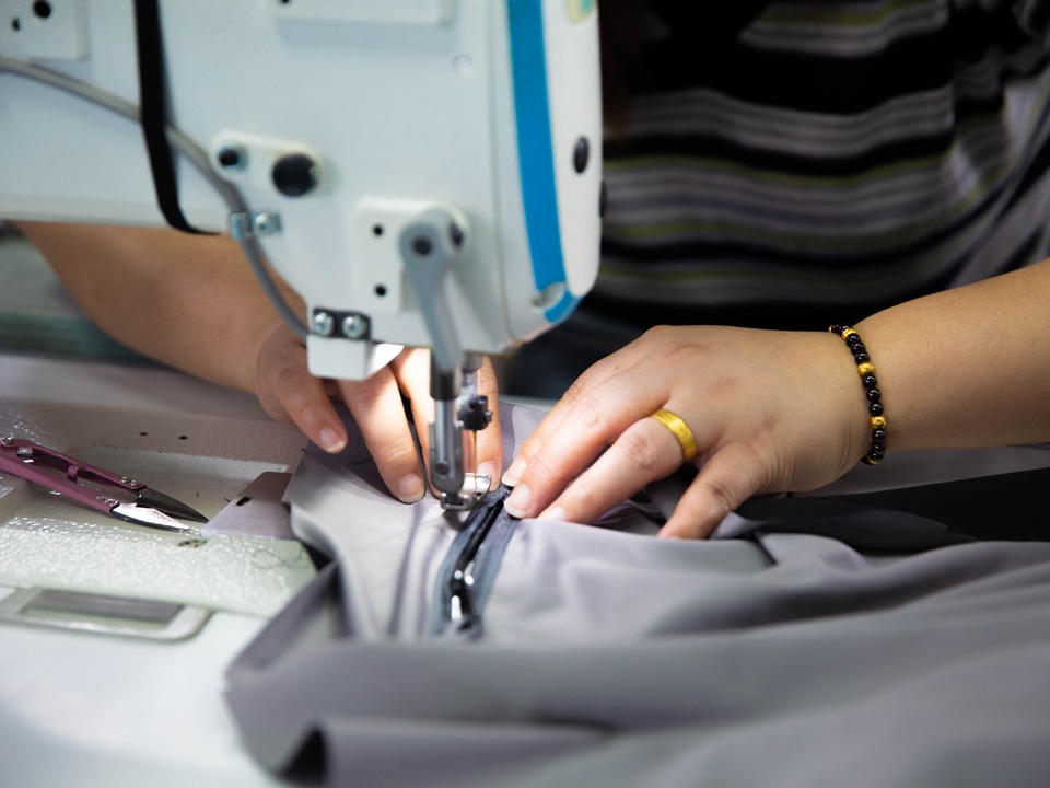 Technician sewing tent components during OEM sample production at NastoCamp