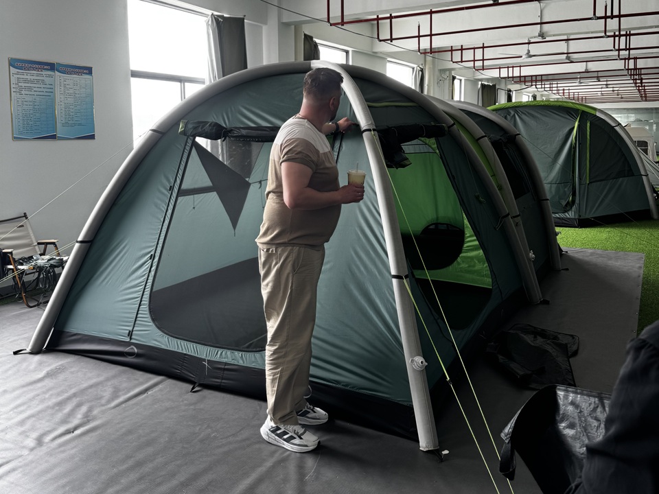Russian customer inspecting a NastoCamp inflatable tent during a factory visit and product inspection before shipment.