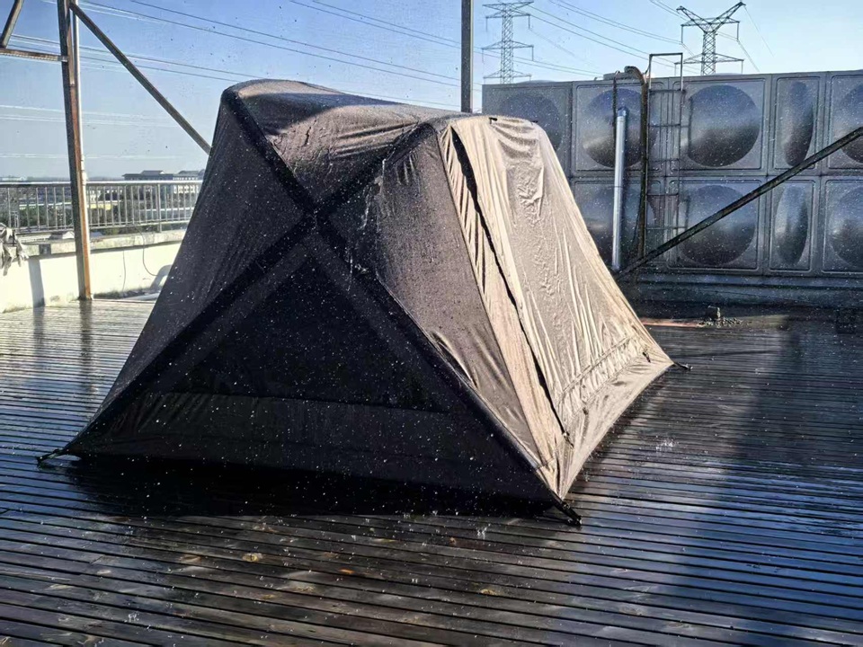 NastoCamp camping tent undergoing a controlled rain test to verify waterproof performance and weather resistance.