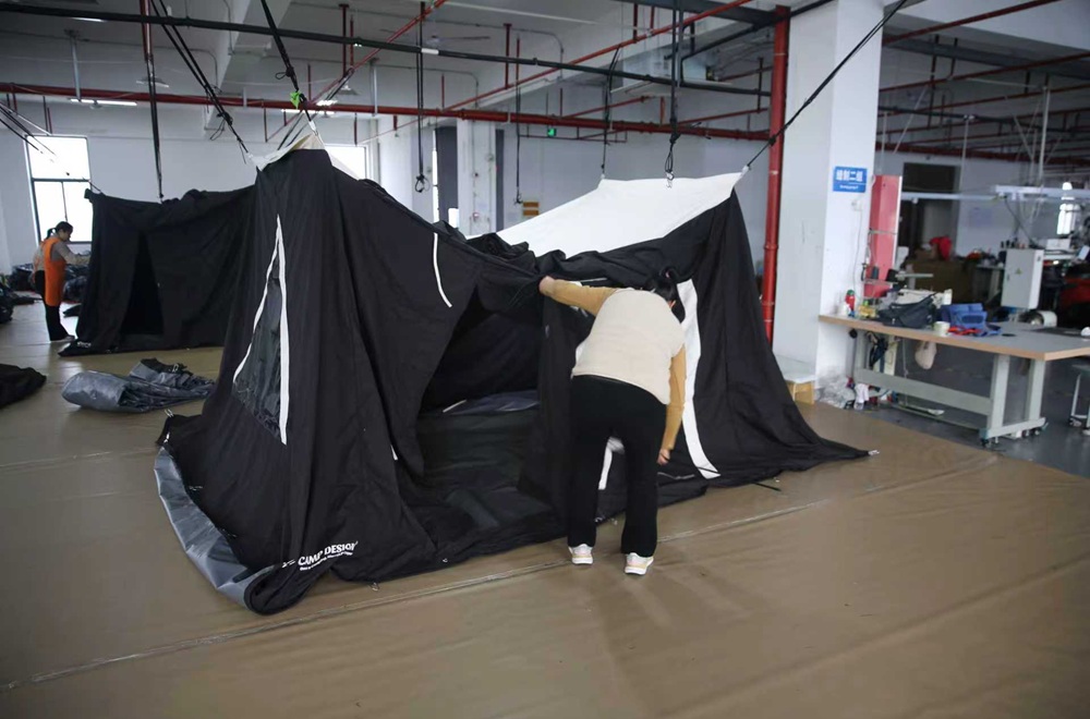 Quality inspector checking tent assembly before shipment