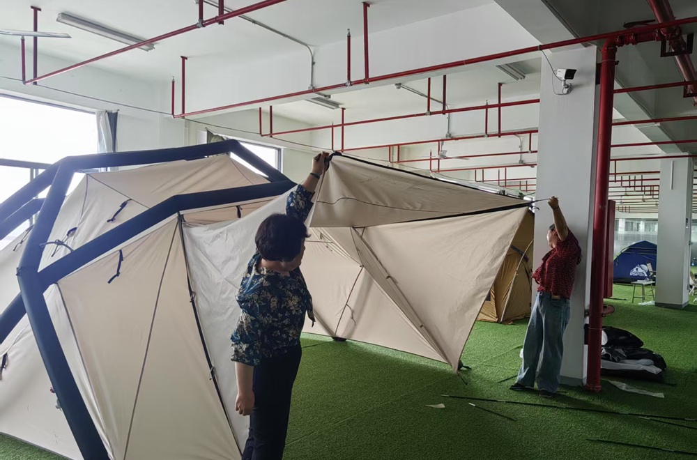 Engineers evaluating an inflatable tent prototype during product development.