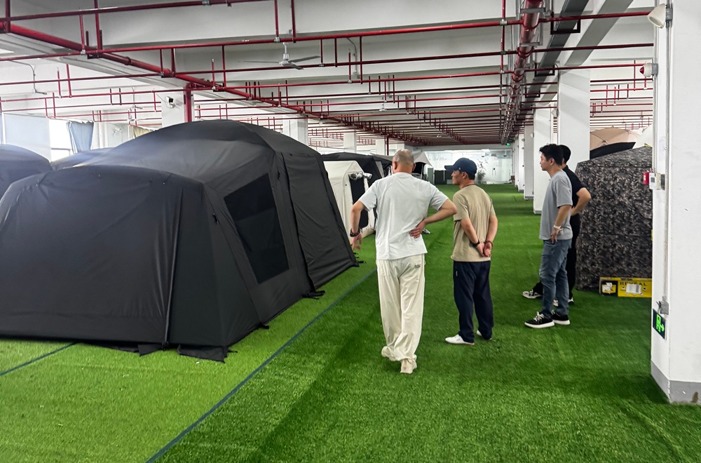 Customer inspecting tent samples inside NastoCamp OEM tent manufacturing facility