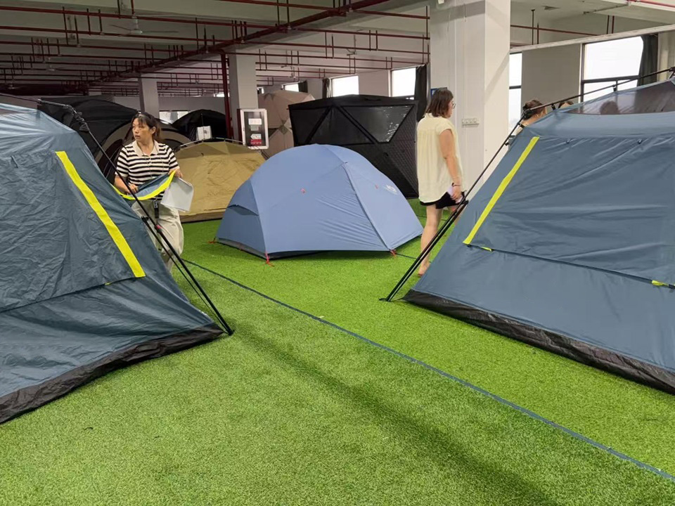 NastoCamp workers inspecting pre-production tent samples before mass production
