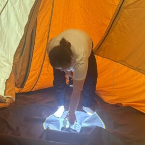 NastoCamp engineer inspecting a tent interior during rain testing to identify waterproof leakage points