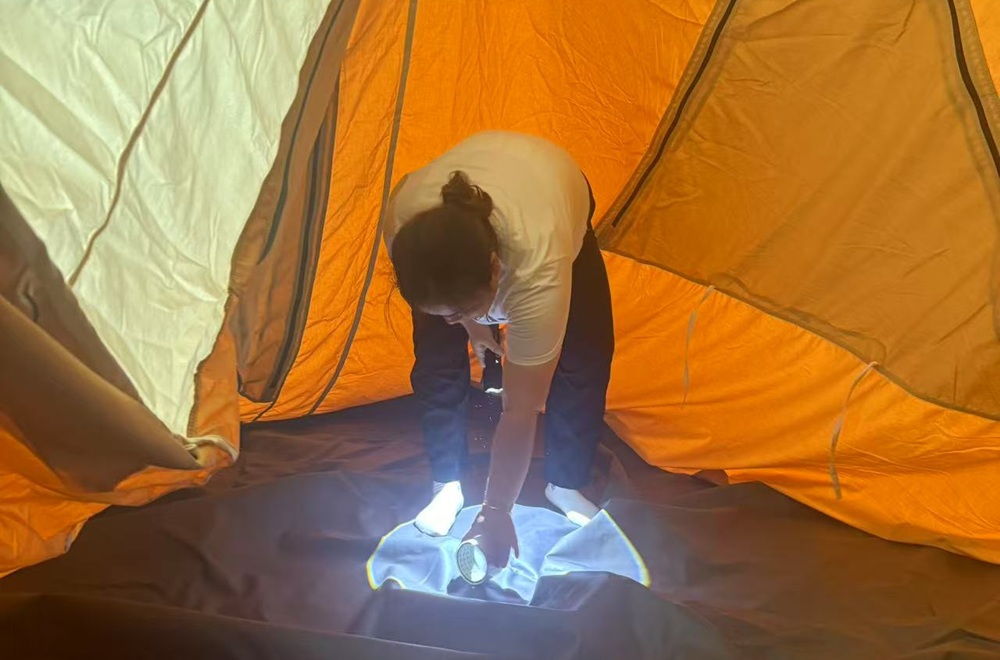NastoCamp engineer inspecting a tent interior during rain testing to identify waterproof leakage points