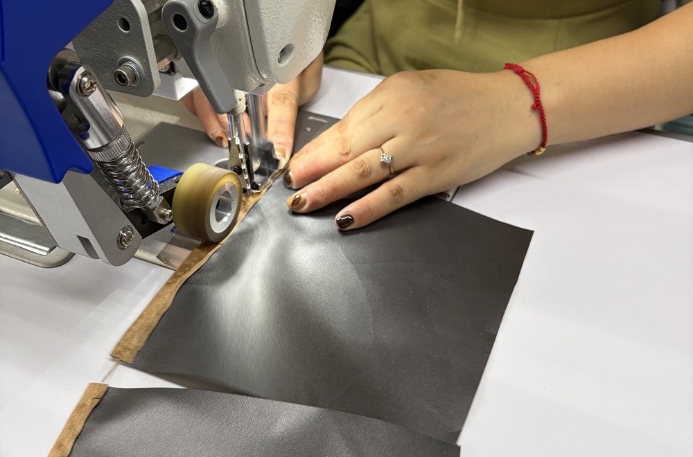 Worker applying waterproof seam tape during tent manufacturing process