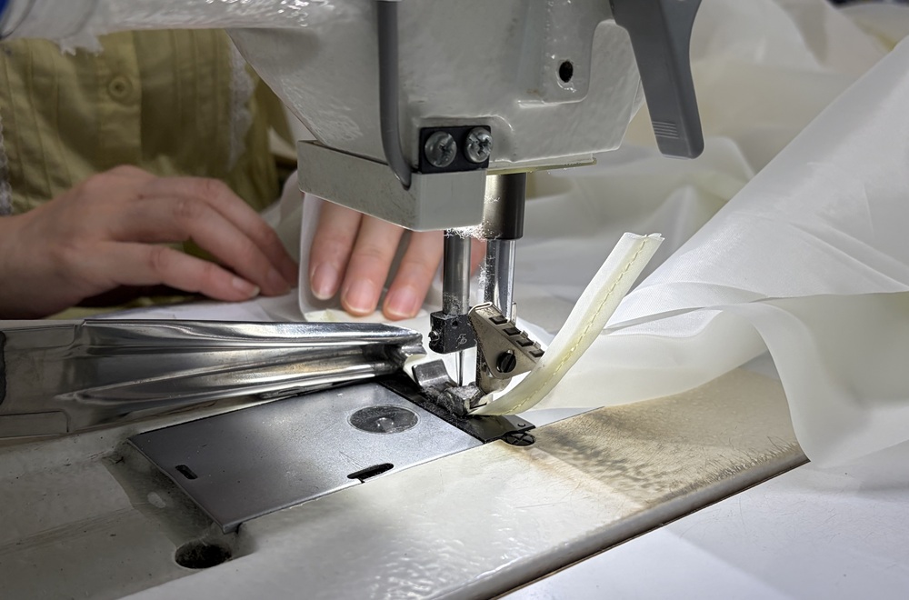 Close-up tent sewing process showing stitching that creates potential needle holes