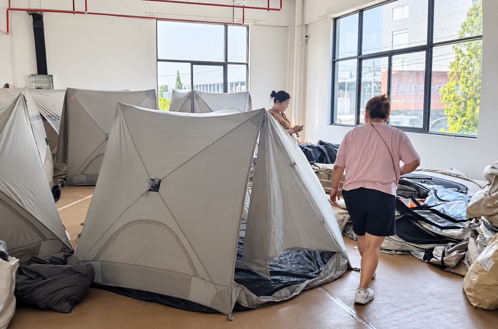 NastoCamp team inspecting finished tents during quality control at the factory
