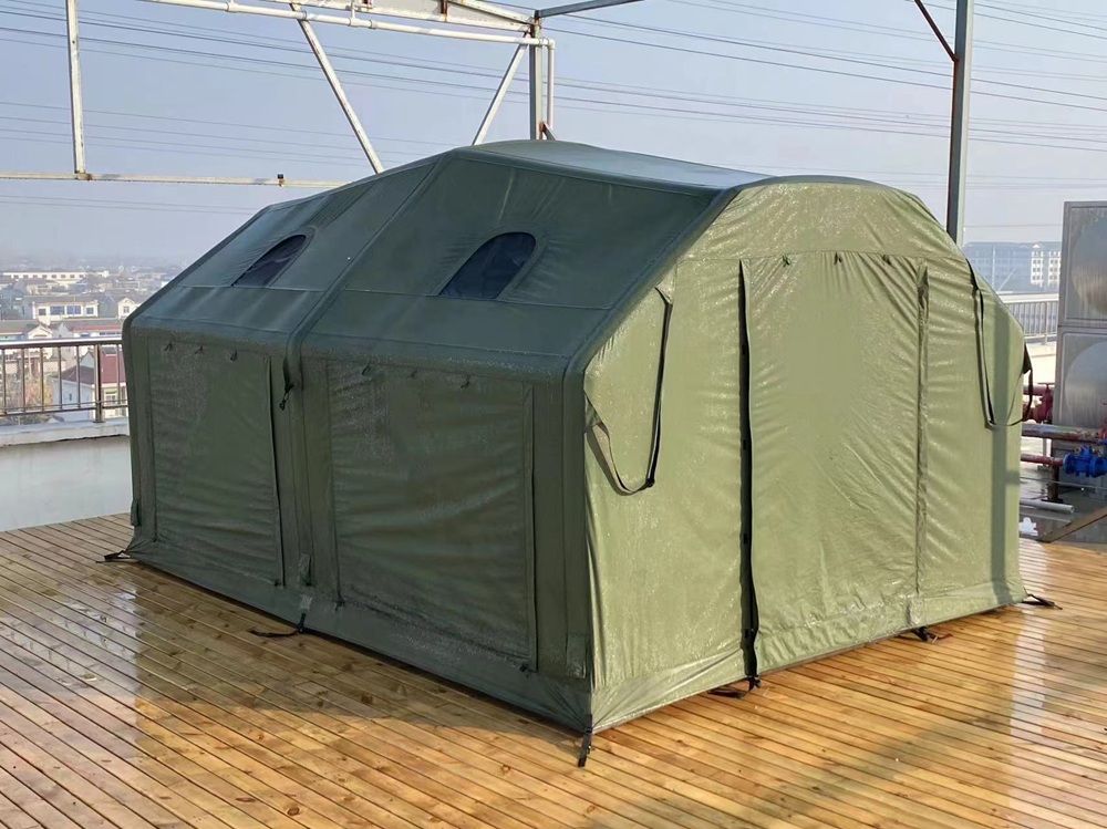 Green polycotton air tent set up outdoors on a wooden platform