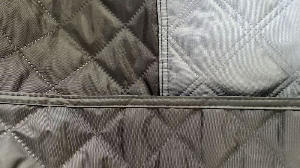 Close-up of a stitched seam on gray quilted tent fabric
