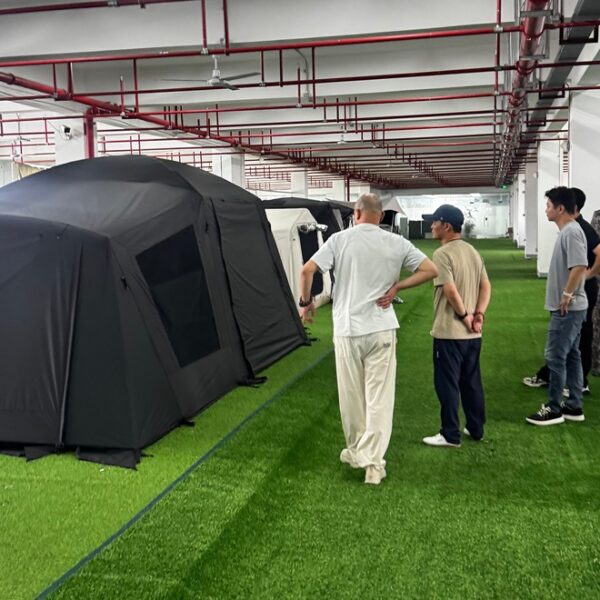 Customer inspecting tent samples inside NastoCamp OEM tent manufacturing facility
