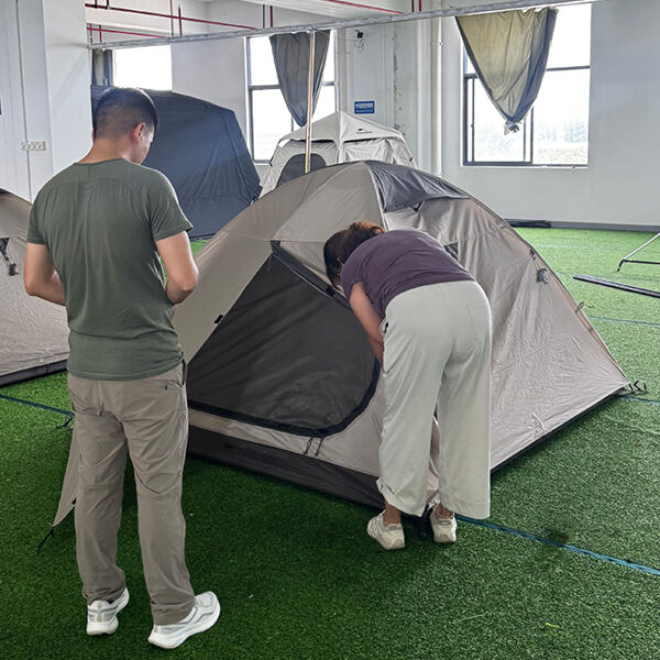 Outdoor Brand Reviewing Custom Tent Sample During OEM Development Outdoor brand representative reviewing a custom tent sample during OEM product development